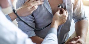 Doctor using a stethoscope checking patient with examining, pres Doctor using a stethoscope checking patient with examining, presenting results symptom and recommend treatment method, Healthcare and medical concept.